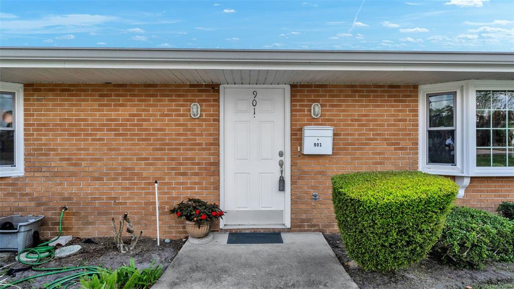 A brick house exterior features a white front door with the number 901 — 901 WOODWARD STREET, LAKELAND, FL