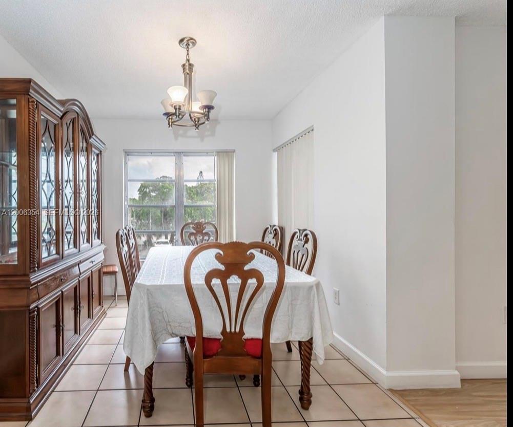 A dining room features a wooden hutch, a table with chairs, and tile flooring — 4174 Inverrary Dr # 202, Lauderhill FL 33319, LAUDERHILL, FL