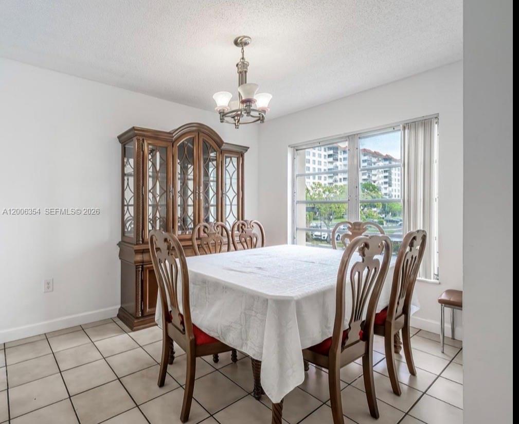 A dining room features a wooden hutch, a table with chairs, and tiled flooring — 4174 Inverrary Dr # 202, Lauderhill FL 33319, LAUDERHILL, FL
