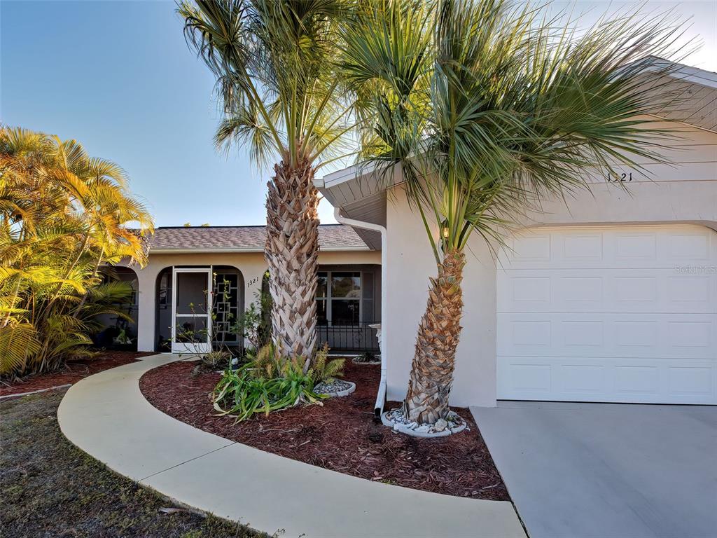 A curved walkway leads to the front entrance of a house with two palm trees — 1321 WASHINGTON DRIVE, ENGLEWOOD, FL