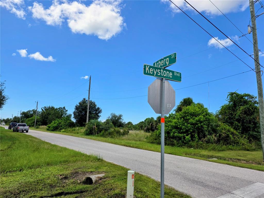 A street sign at the intersection of Arberg St and Keystone Blvd under a blue sky — 9177 ARBERG STREET, PORT CHARLOTTE, FL