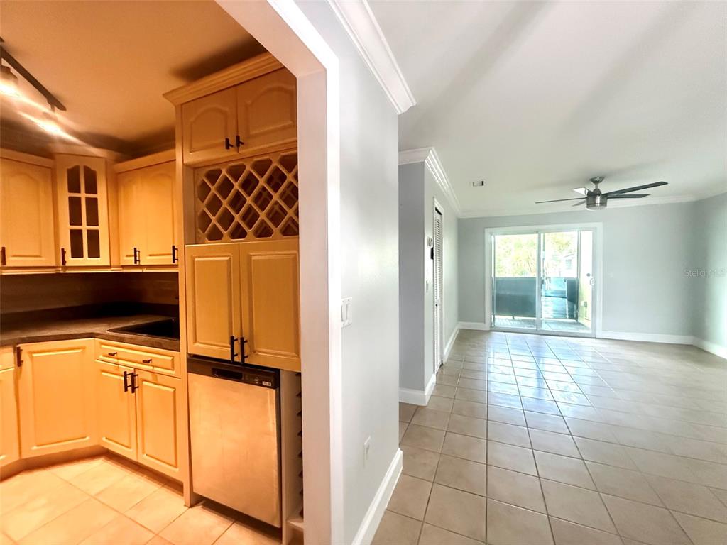 A kitchen with light wood cabinets and a wine rack opens into a tiled living area — 926 LAKE DESTINY ROAD UNIT F, ALTAMONTE SPRINGS, FL