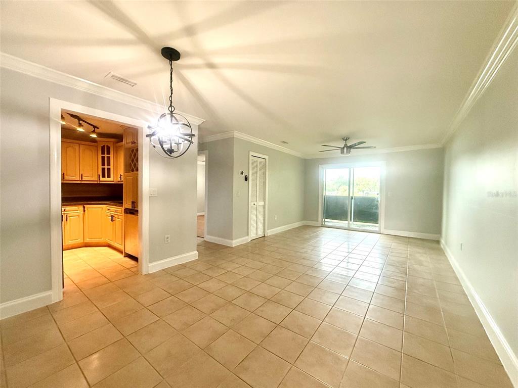 A dining area with tile floors leads into a kitchen with light wood cabinets — 926 LAKE DESTINY ROAD UNIT F, ALTAMONTE SPRINGS, FL