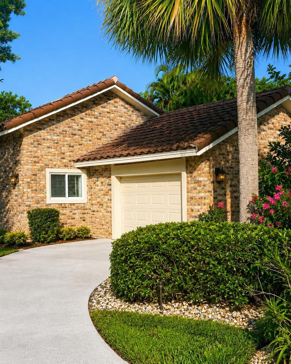 A brick house with a curved driveway is surrounded by palm trees and lush landscaping — 10562 Fenway Place, Boca Raton FL 33498, BOCA RATON, FL