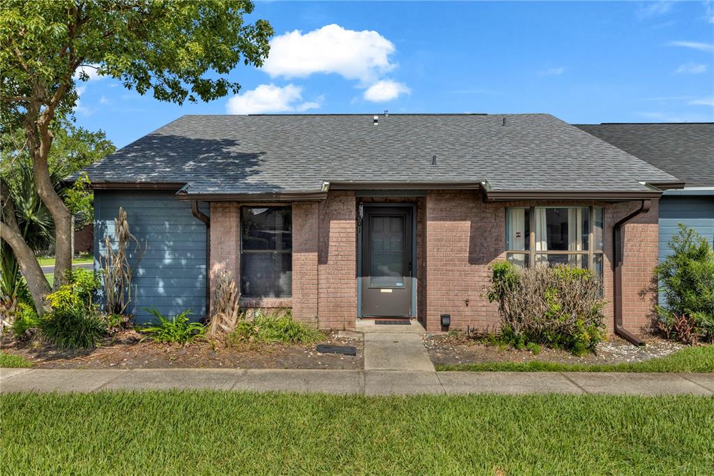 A single-story brick and blue-sided house with a gray shingled roof and front lawn — 2501 KING OAK CIRCLE, ST CLOUD, FL