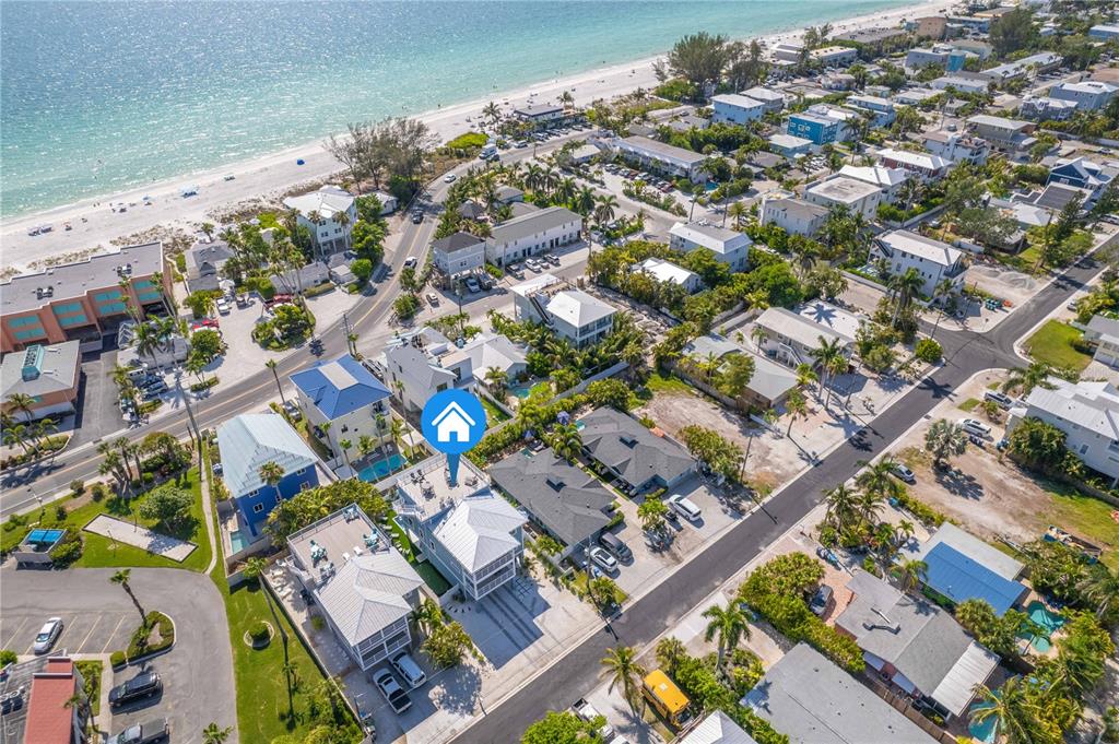 An aerial view shows a coastal neighborhood with houses, streets, and a nearby beach — 2102 AVENUE B, BRADENTON BEACH, FL
