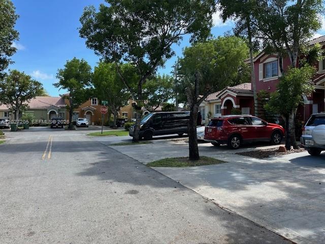 A street view shows residential buildings, parked cars, and trees under a blue sky — 160 SW 16th Ave, Homestead FL 33030, HOMESTEAD, FL