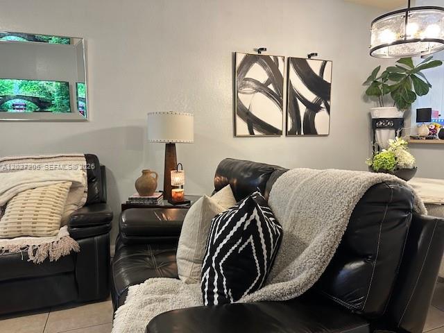 A living room features black leather furniture, abstract wall art, and a decorative table lamp — 160 SW 16th Ave, Homestead FL 33030, HOMESTEAD, FL
