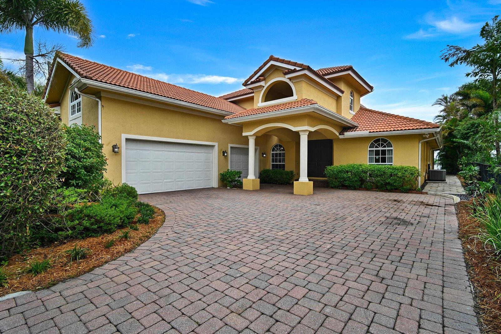 A yellow two-story house with a tile roof and a paved driveway — 881 SE Saint Lucie Boulevard, Stuart FL 34996, STUART, FL