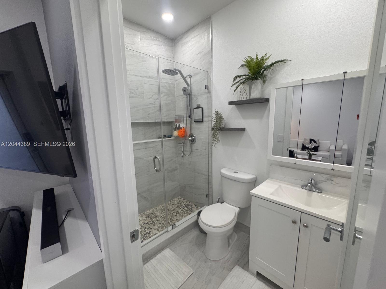 A small bathroom features a glass-enclosed shower, a white vanity, and a toilet — 3265 SW 153rd Pl # 1, Miami FL 33185, MIAMI, FL