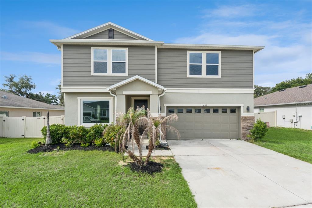 A two-story house with gray horizontal siding, a stucco lower level, and a two-car garage — 15898 BRADICKS COURT, CLERMONT, FL