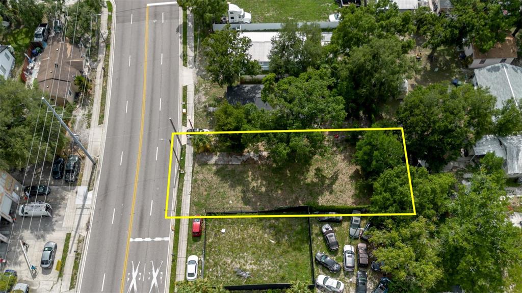 An aerial view shows a rectangular vacant lot outlined in yellow next to a road — 3010 E DR MLK, TAMPA, FL