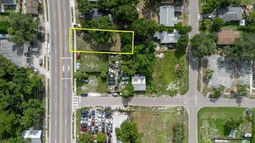 An aerial view shows a vacant rectangular lot outlined in yellow near a city street — 3010 E DR MLK, TAMPA, FL