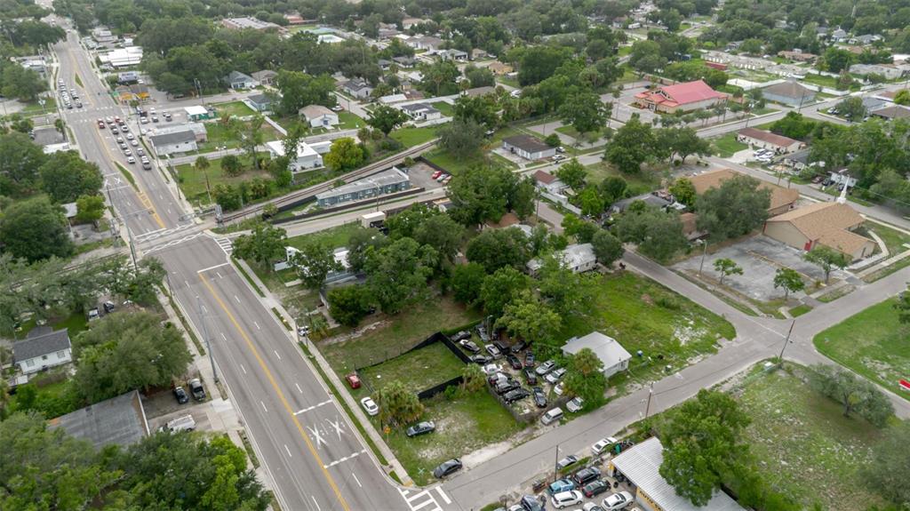 An aerial view shows a city street, a fenced car lot, and surrounding residential buildings — 3010 E DR MLK, TAMPA, FL