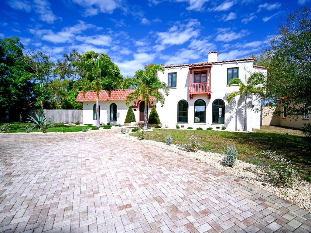 A two-story white stucco house with a red tile roof and a paved driveway — 6251 10TH AVENUE S, GULFPORT, FL
