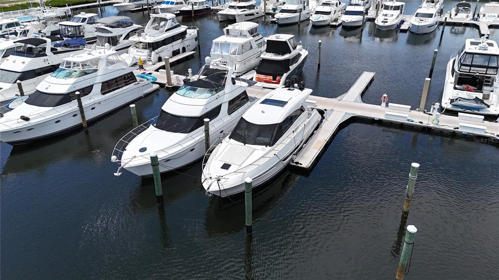 An aerial view shows several white yachts docked at a marina — 102 RIVIERA DUNES WAY UNIT C-50, PALMETTO, FL