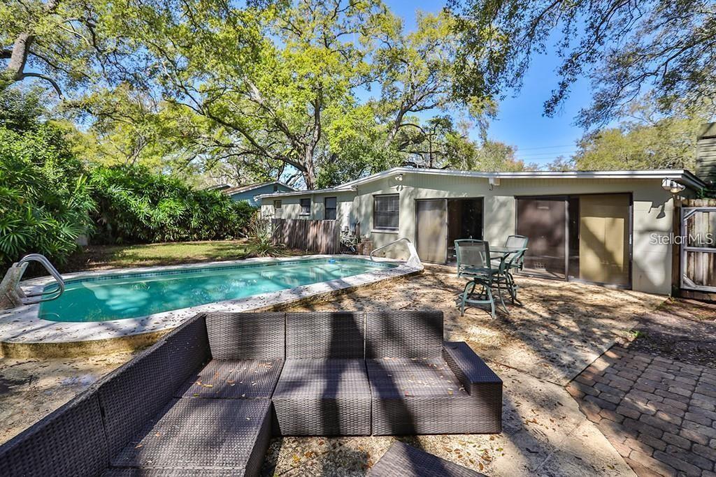A backyard features a swimming pool, a patio with outdoor furniture, and a single-story house — 3214 W COACHMAN AVENUE, TAMPA, FL