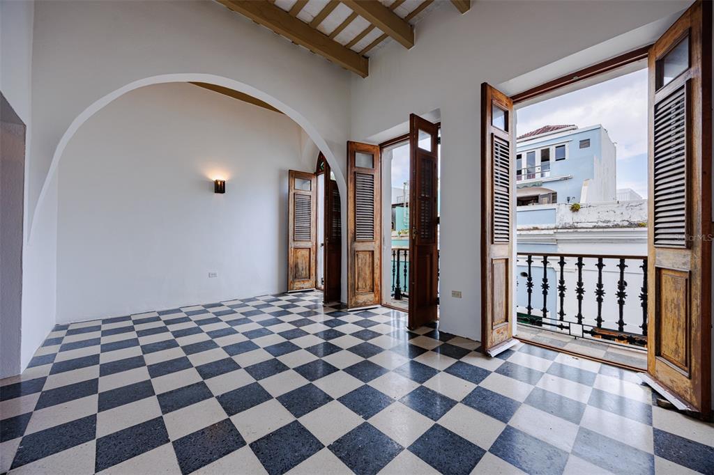An empty room features a black and white checkered floor, arched ceiling, and open balcony doors — 364 CALLE SOL UNIT 2B, OLD SAN JUAN, PR