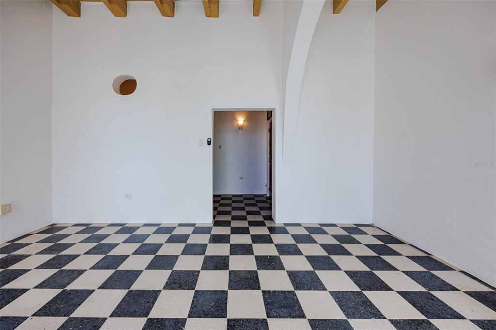 An empty room features a black and white checkered floor, white walls, and exposed ceiling beams — 364 CALLE SOL UNIT 2B, OLD SAN JUAN, PR