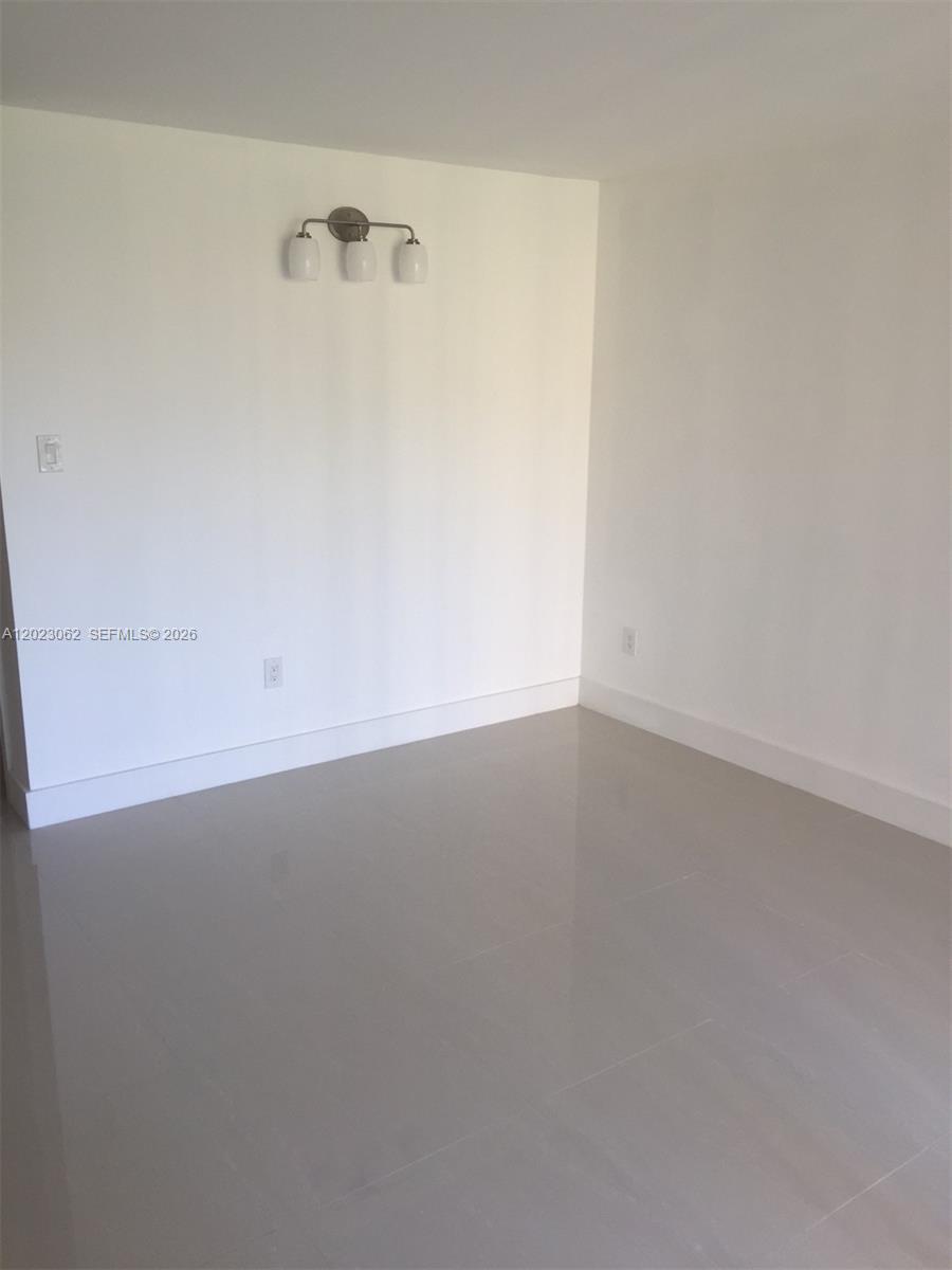 This room features white walls, light-colored tile flooring, and a three-light wall fixture — 4746 NW 97th Ct # 72, Doral FL 33178, DORAL, FL