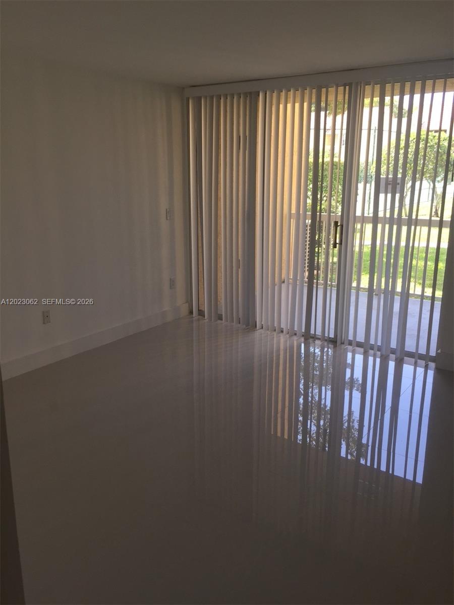 A room with white tile floors and vertical blinds covering a sliding glass door — 4746 NW 97th Ct # 72, Doral FL 33178, DORAL, FL