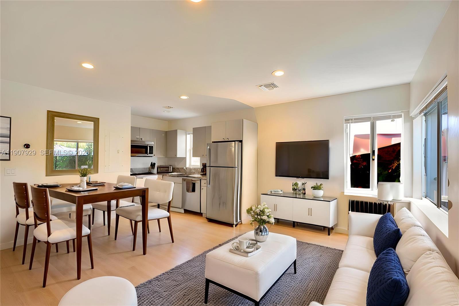 A bright open-concept living and dining area features light wood floors and a modern kitchen — 322 Oklahoma St, Hollywood FL 33019, HOLLYWOOD, FL