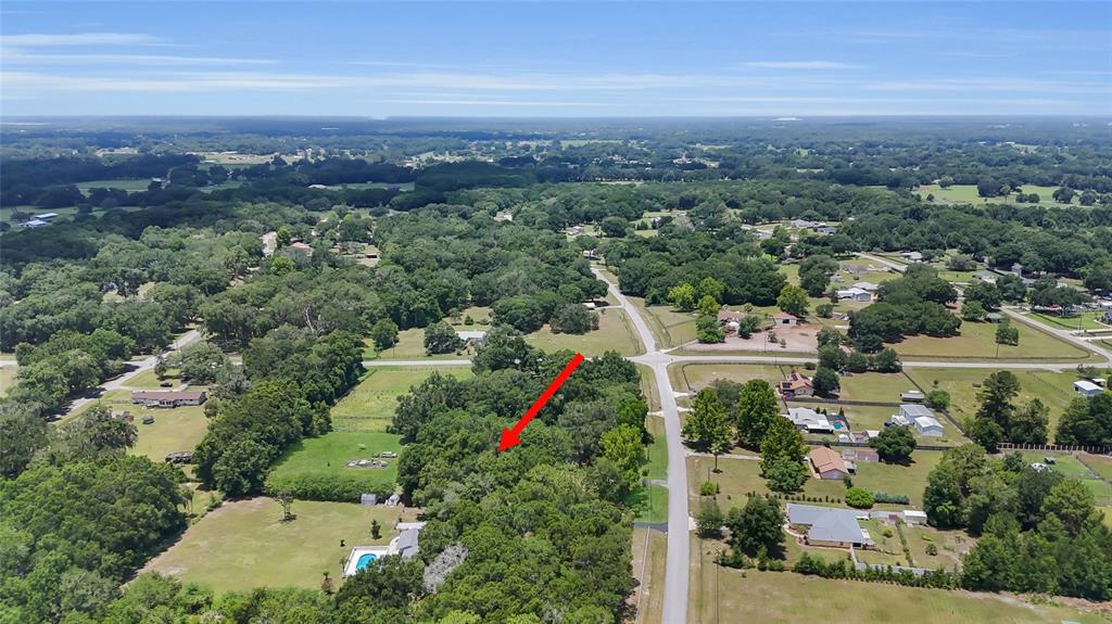 An aerial view shows a wooded lot surrounded by residential properties and rural roads — 2800 SE 157TH LANE ROAD, SUMMERFIELD, FL