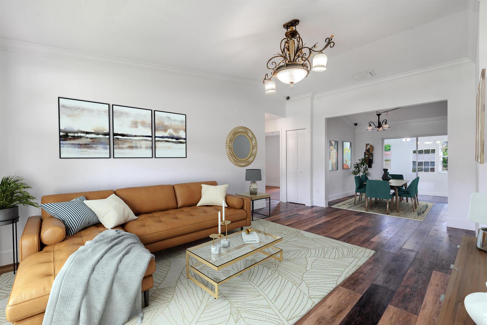 A living room with a leather sofa, glass coffee table, and wood flooring leads to a dining area — 15285 San Diego Drive, FL 33470, FL
