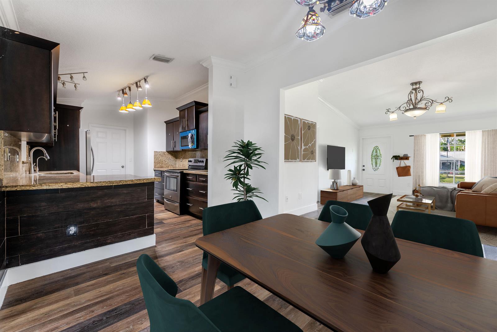 A dining area with dark green chairs opens into a kitchen and a living room — 15285 San Diego Drive, FL 33470, FL