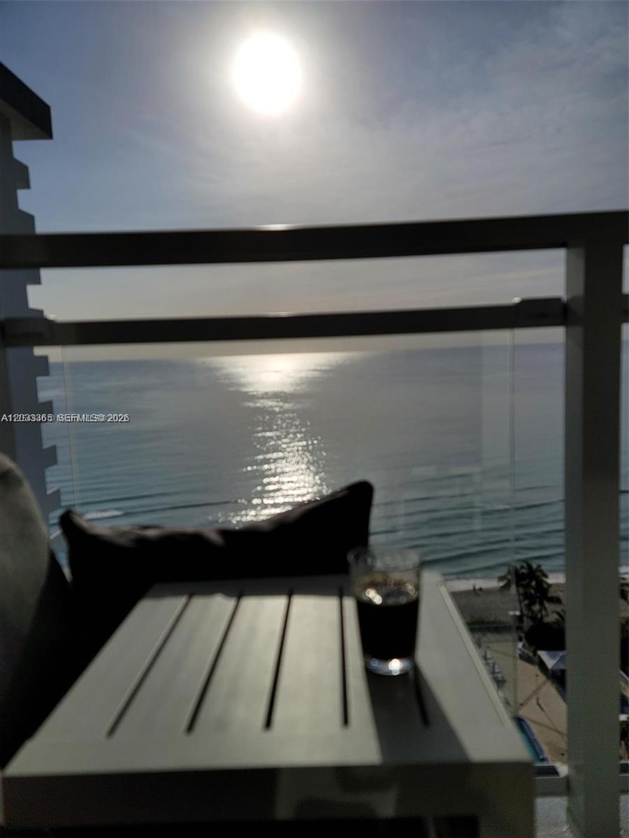 A balcony overlooks the ocean with a small table and a glass of dark liquid — 2030 S Ocean Dr # 1815, Hallandale Beach FL 33009, HALLANDALE BEACH, FL