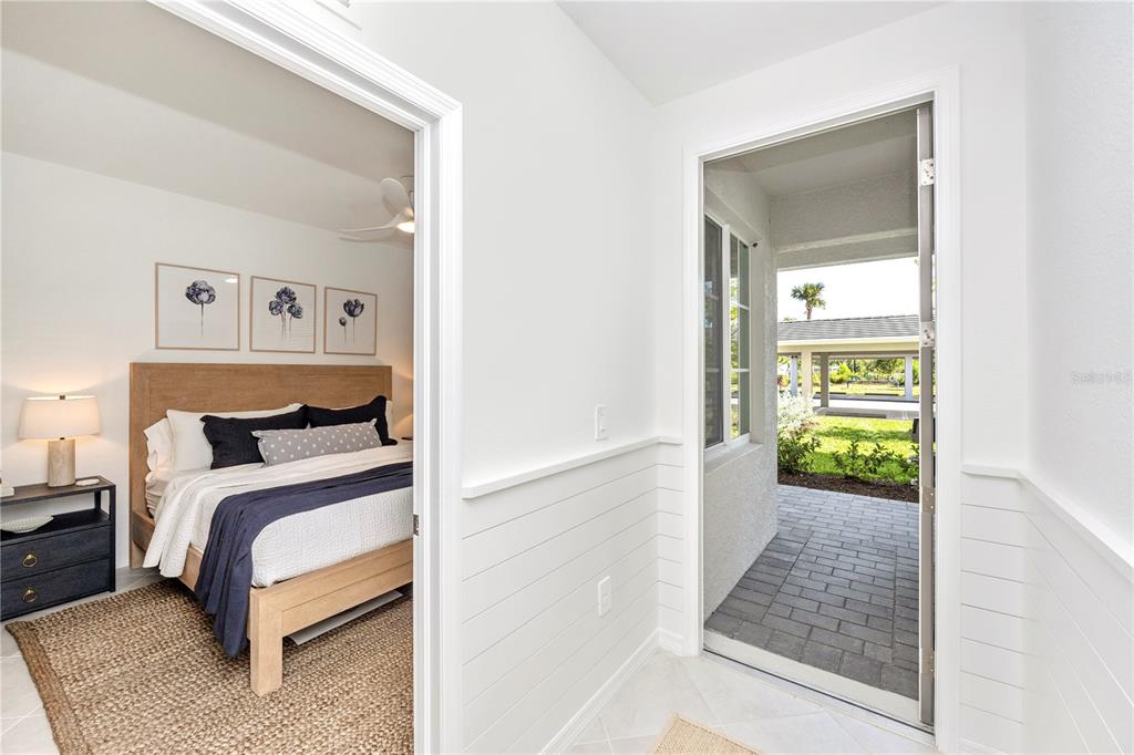 A bedroom with a wooden bed frame is visible through a doorway next to a patio — 17625 OPAL SAND DRIVE UNIT 106, VENICE, FL