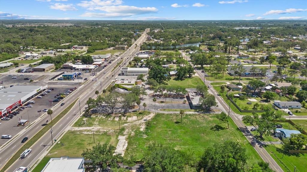 An aerial view shows a vacant grassy lot adjacent to a commercial road and buildings — 610 N US HIGHWAY 41, RUSKIN, FL