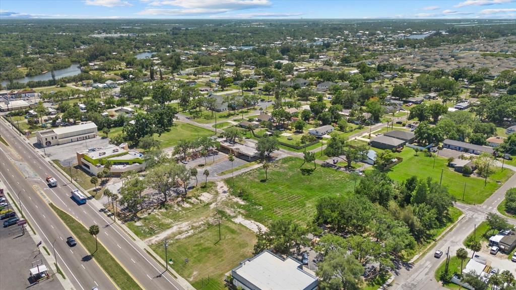An aerial view shows a commercial property with a large vacant lot along a road — 610 N US HIGHWAY 41, RUSKIN, FL