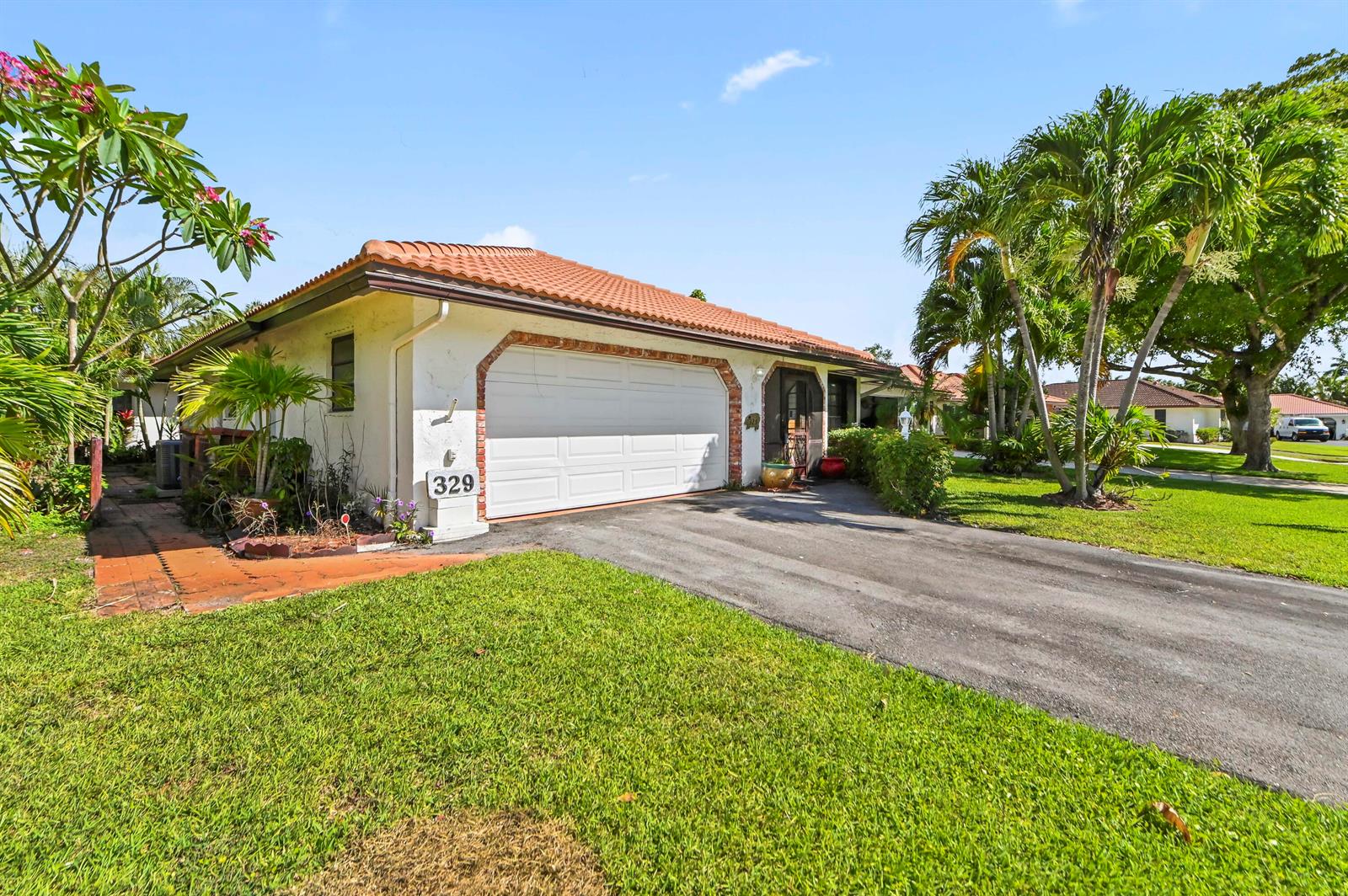 A single-story house with a white garage door, red tile roof, and a paved driveway — 329 Knob Hill Boulevard, Boca Raton FL 33431, BOCA RATON, FL