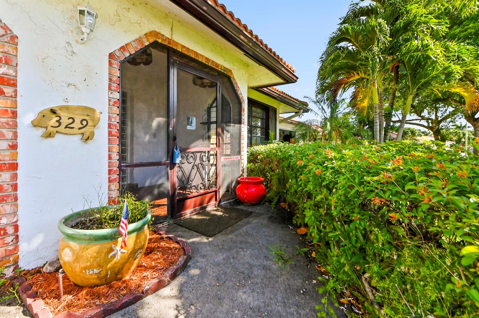 A house exterior features a pig-shaped address sign, a screen door, and a potted plant — 329 Knob Hill Boulevard, Boca Raton FL 33431, BOCA RATON, FL