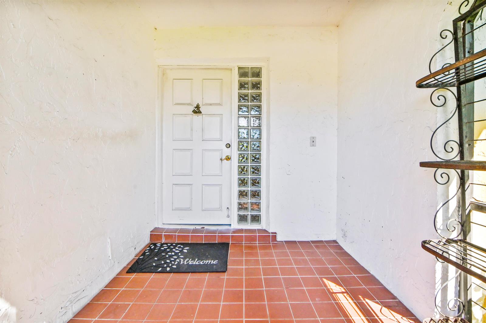 A white front door with glass block sidelights opens onto a tiled entryway porch — 329 Knob Hill Boulevard, Boca Raton FL 33431, BOCA RATON, FL
