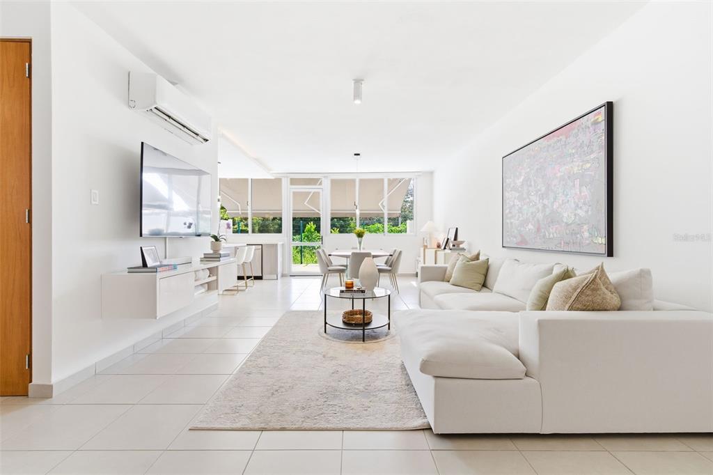 A bright living room features white tile floors, a sectional sofa, and a wall-mounted television — 111 CALLE 3, GUAYNABO, PR