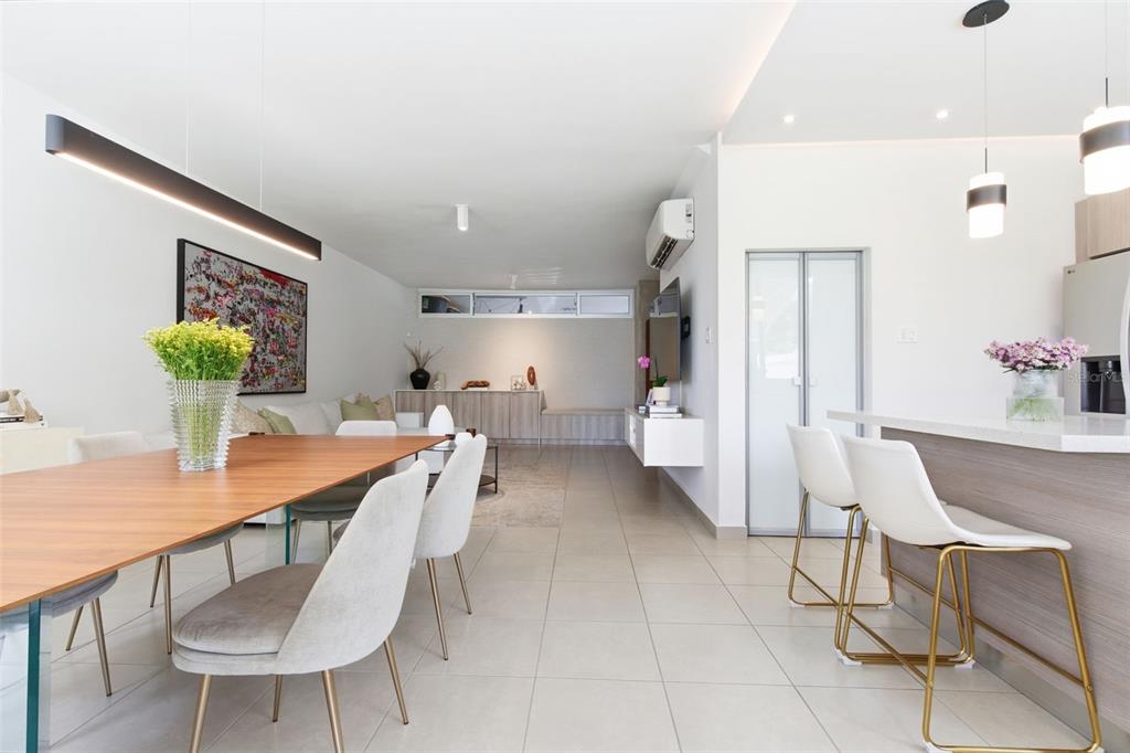 A modern open-concept dining and kitchen area with light tile floors and white bar stools — 111 CALLE 3, GUAYNABO, PR