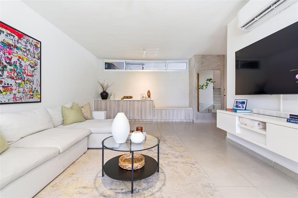 A bright living room features a white sectional sofa, a glass coffee table, and television — 111 CALLE 3, GUAYNABO, PR