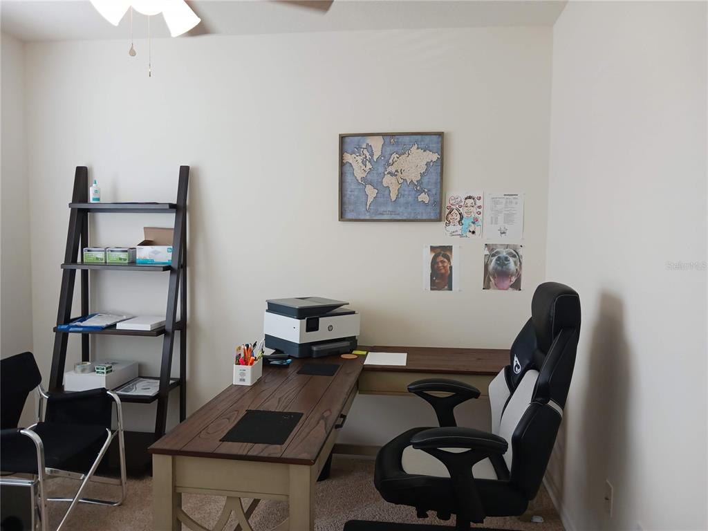 A home office features a wooden L-shaped desk, a gaming chair, and a ladder-style bookshelf — 563 HONEY BELL ROAD, WINTER HAVEN, FL