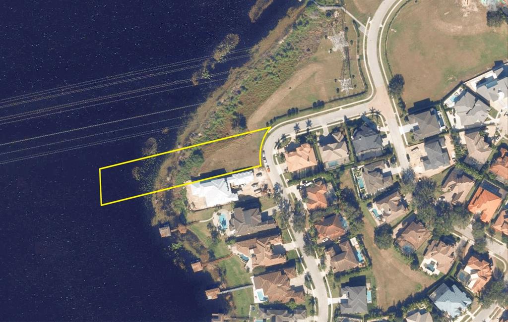 An aerial view shows a vacant waterfront lot outlined in yellow next to a residential street — 5727 EMERINGTON CRESCENT, ORLANDO, FL