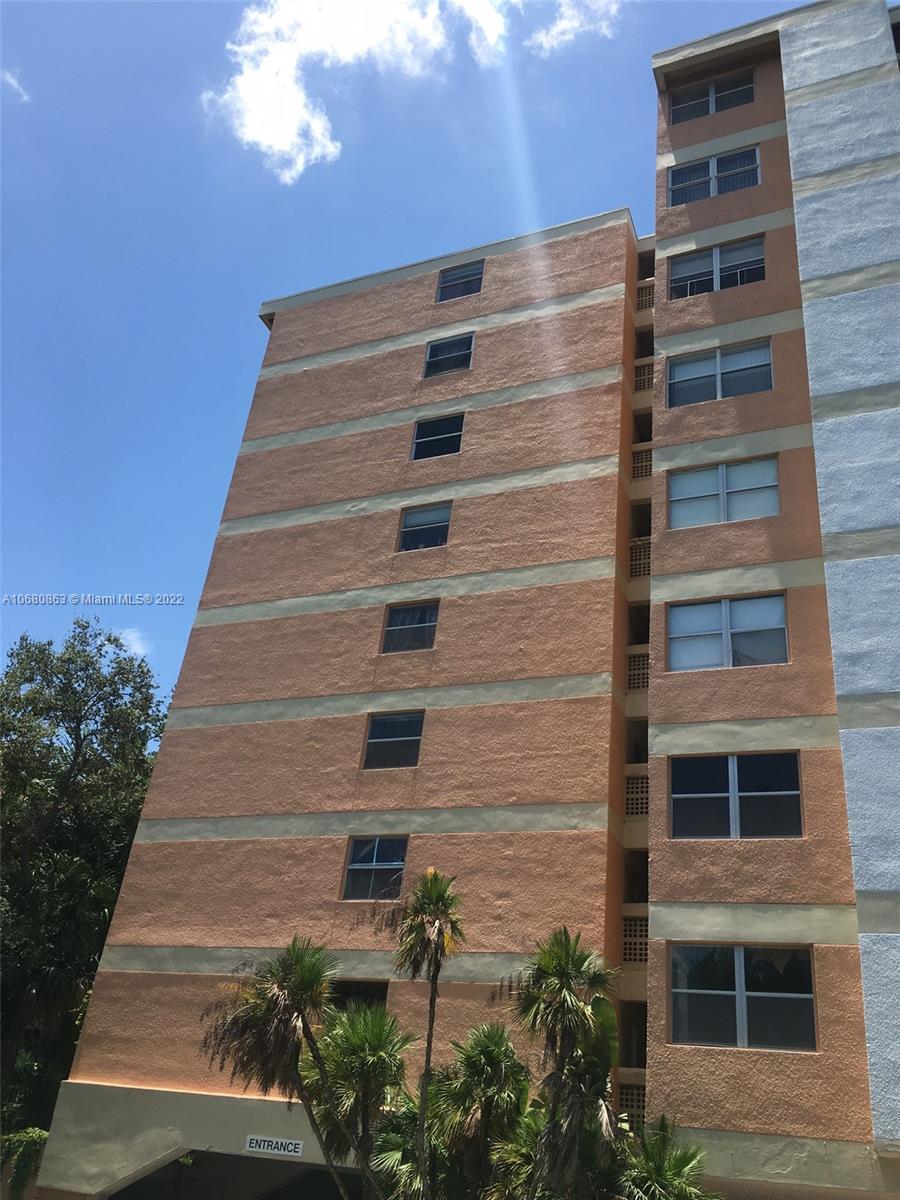 A multi-story apartment building exterior features peach-colored walls with a vertical row of windows — 3301 Spanish Moss Ter # 906, Lauderhill FL 33319, LAUDERHILL, FL