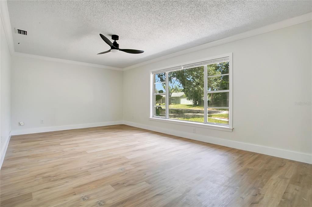 An empty room with light wood-look flooring, white walls, and a black ceiling fan — 1221 FOREST CIRCLE, ALTAMONTE SPRINGS, FL