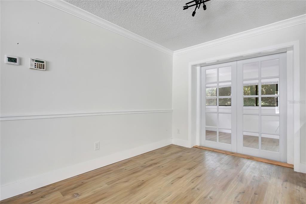A room with light wood-look flooring, white walls with chair rail molding, and French doors — 1221 FOREST CIRCLE, ALTAMONTE SPRINGS, FL