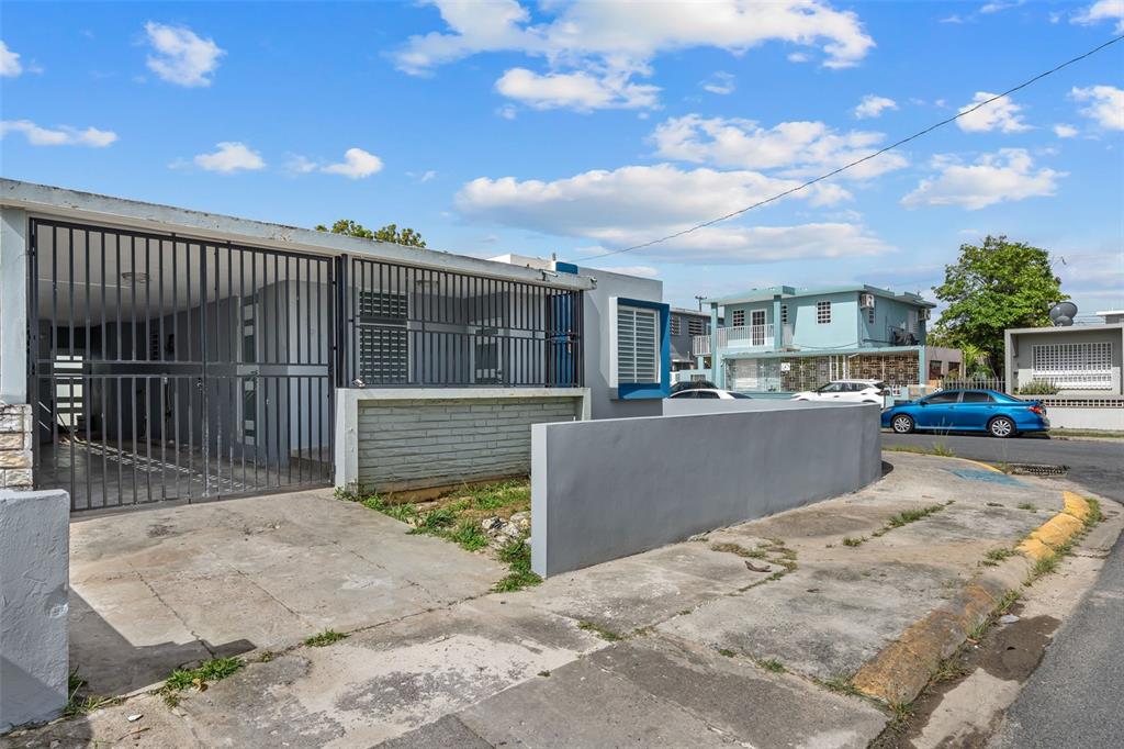 A single-story house with a gated carport and a low concrete wall along the sidewalk — 1210 CALLE MARIA BUSTAMANTE, SAN JUAN, PR