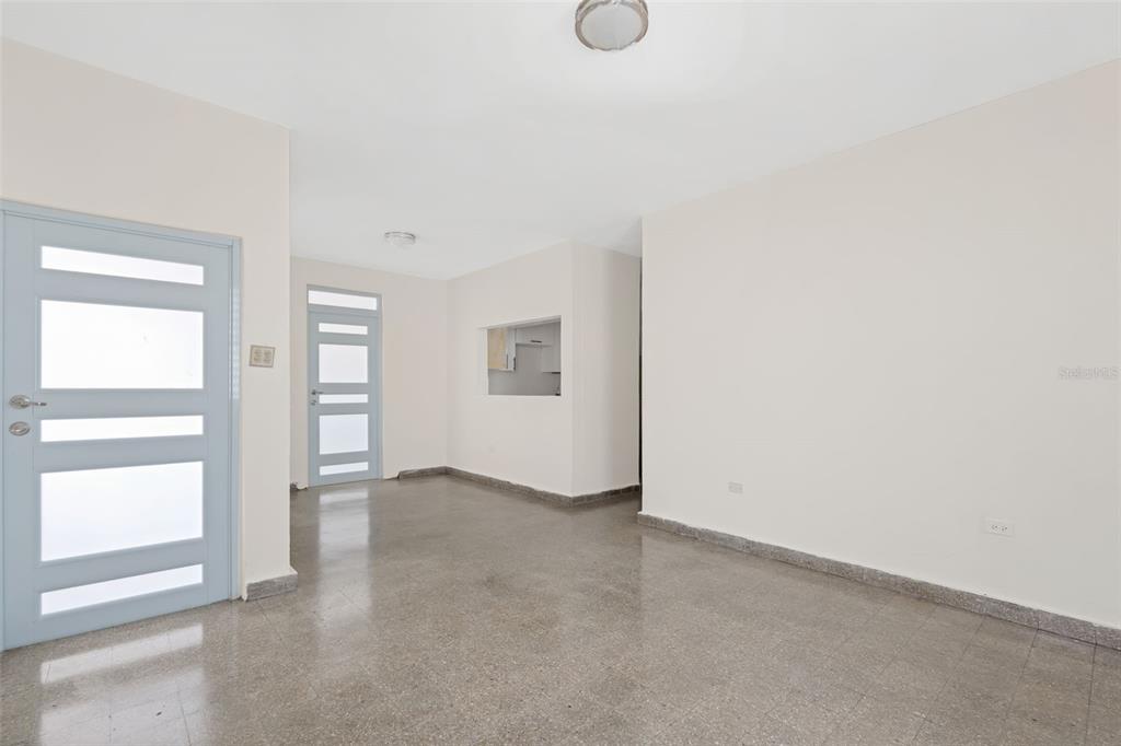 An empty room with light-colored walls, a light blue door, and speckled tile flooring — 1210 CALLE MARIA BUSTAMANTE, SAN JUAN, PR