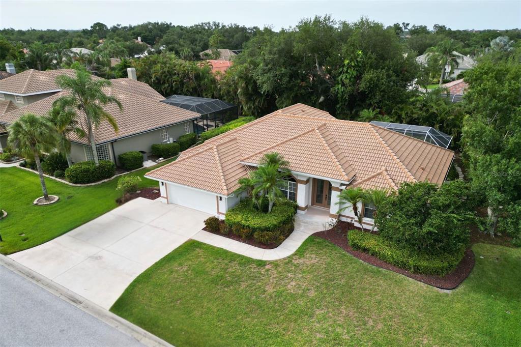An aerial view of a single-story house with a tiled roof and a concrete driveway — 4824 HANGING MOSS LANE, SARASOTA, FL