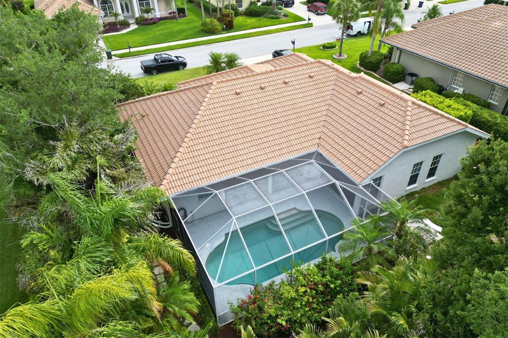 An aerial view shows a house with a tiled roof and a screened-in swimming pool — 4824 HANGING MOSS LANE, SARASOTA, FL