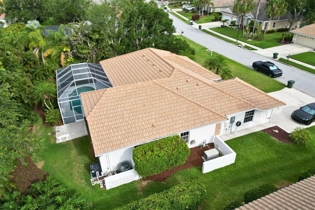 An aerial view of a single-story house with a tiled roof and a screened-in pool — 4824 HANGING MOSS LANE, SARASOTA, FL