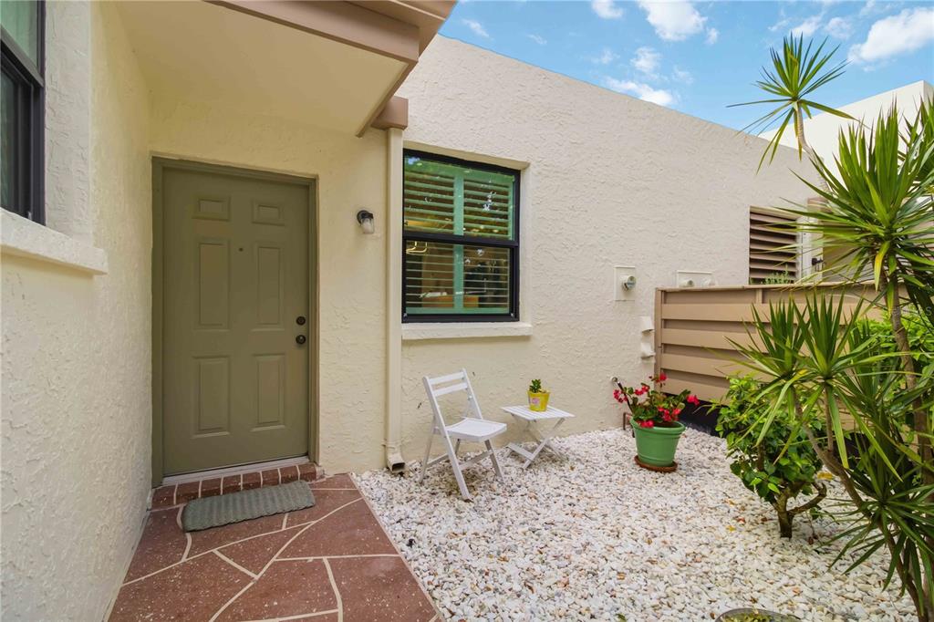 A sidewalk leads to the entrances of three residential units with privacy fences and landscaping — 149 PINEHURST DRIVE UNIT 149, BRADENTON, FL